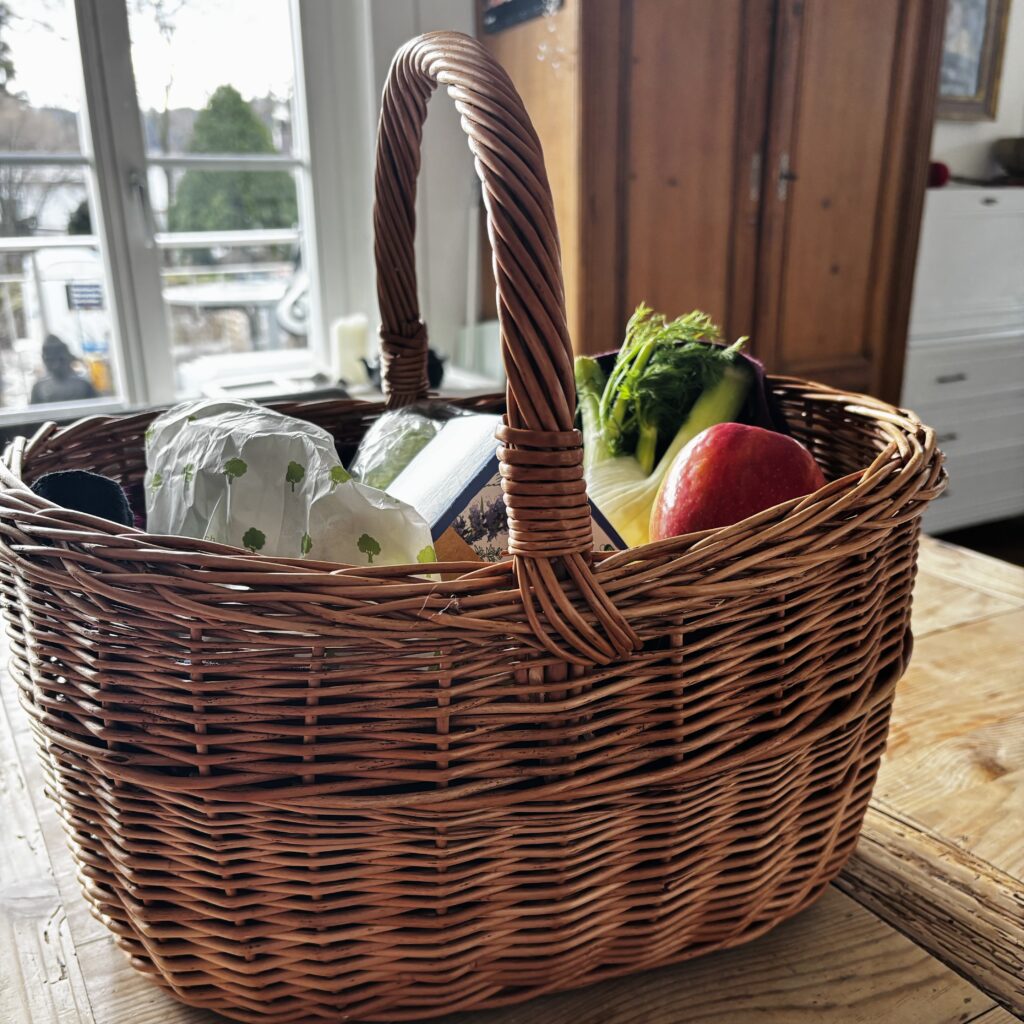 Ein voller Einkaufskorb steht auf einem Küchentisch